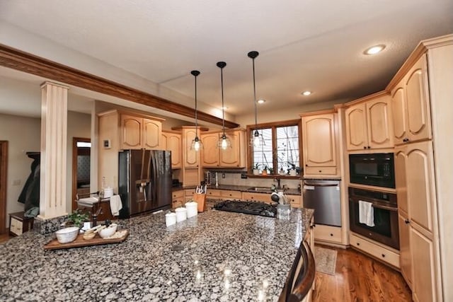 kitchen featuring black appliances, dark stone countertops, light brown cabinets, and light wood-type flooring