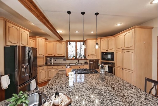 kitchen with black appliances, dark stone countertops, and light brown cabinetry