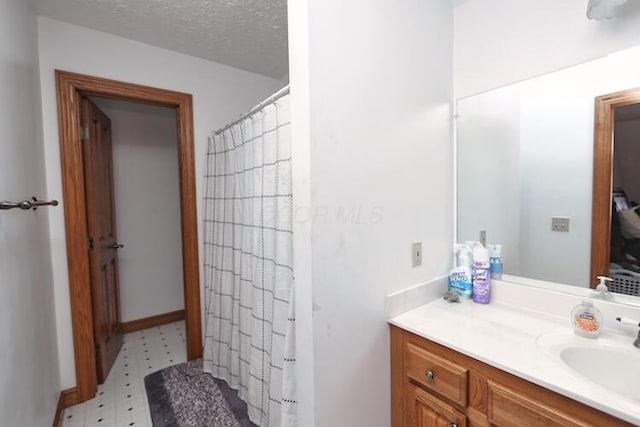 full bath featuring tile patterned floors, a shower with curtain, a textured ceiling, and vanity