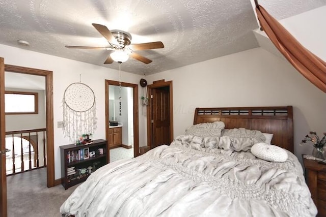 bedroom with light carpet, a textured ceiling, lofted ceiling, and a ceiling fan