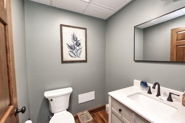 bathroom with toilet, wood finished floors, and vanity