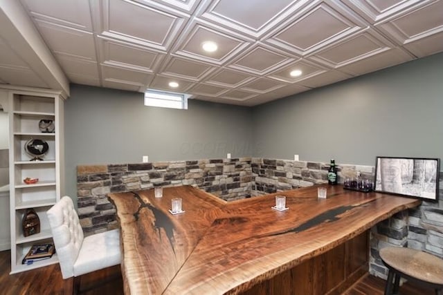 bar featuring recessed lighting, a bar, and wood finished floors