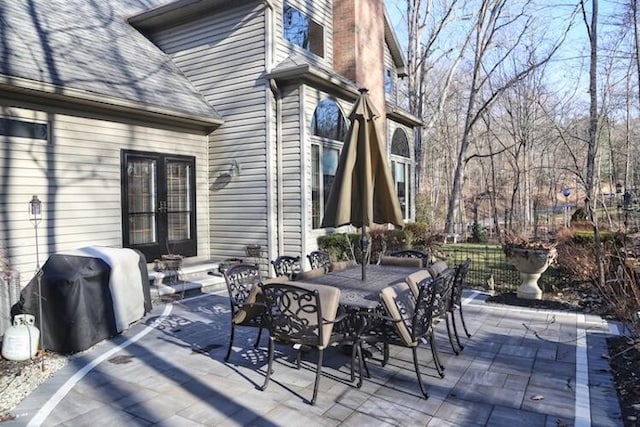 view of patio with outdoor dining space, french doors, and grilling area