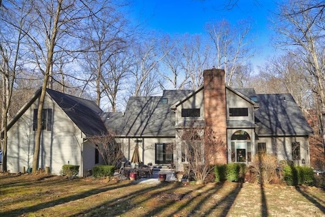 back of property featuring a yard and a chimney