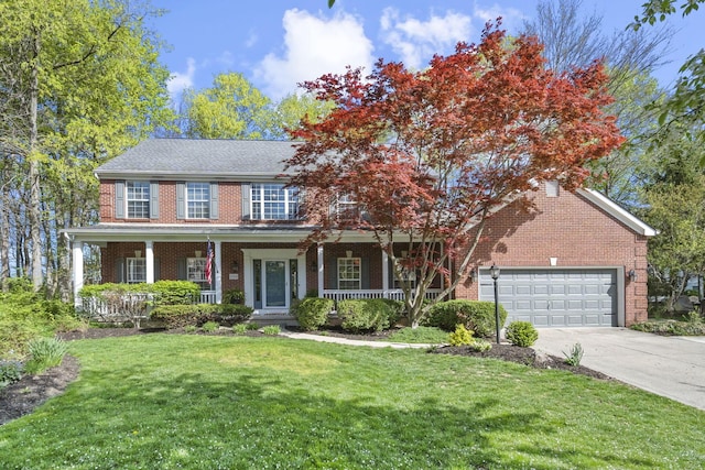 colonial inspired home with a porch, a front yard, brick siding, concrete driveway, and an attached garage