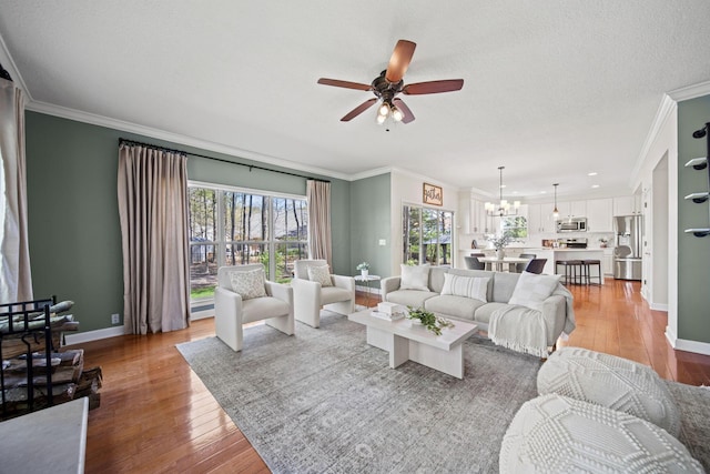 living area featuring baseboards, wood finished floors, and ceiling fan with notable chandelier