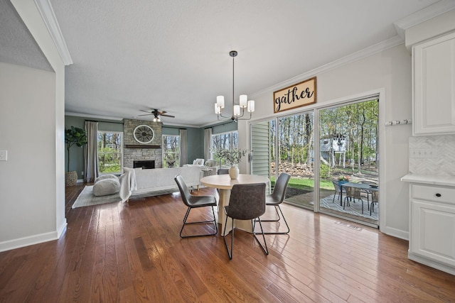 dining space with dark wood-style floors, ornamental molding, and plenty of natural light