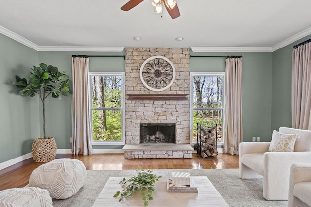 living area featuring a wealth of natural light, ceiling fan, and crown molding
