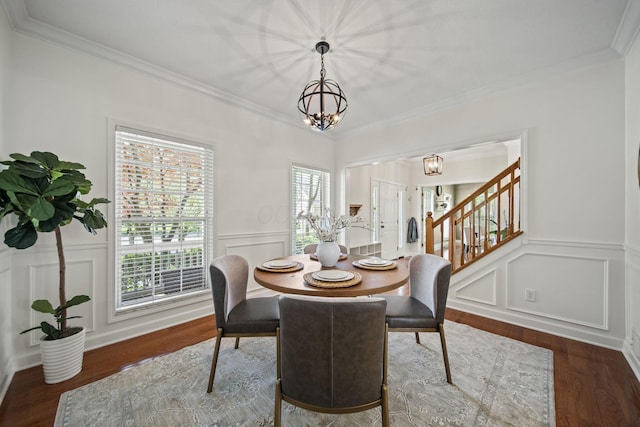 dining space with wood finished floors, an inviting chandelier, stairs, a decorative wall, and ornamental molding