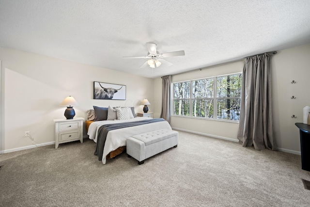 carpeted bedroom featuring a textured ceiling, ceiling fan, and baseboards