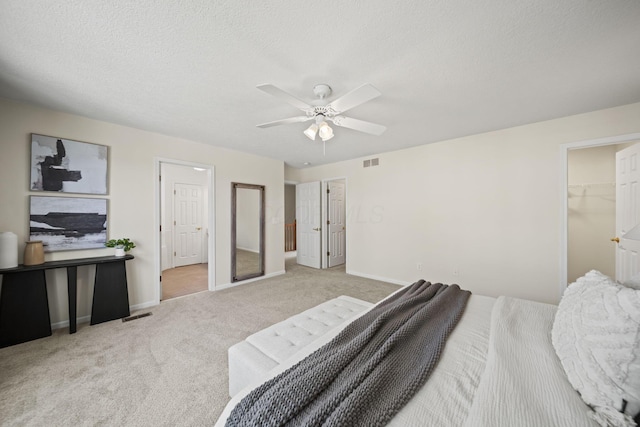 bedroom featuring a textured ceiling, carpet flooring, visible vents, ceiling fan, and baseboards