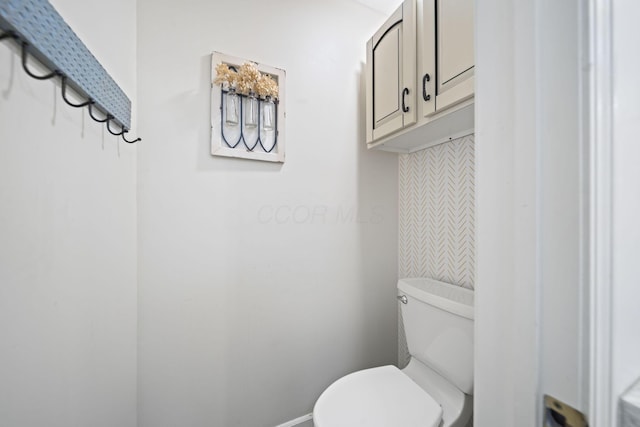 bathroom featuring toilet and baseboards