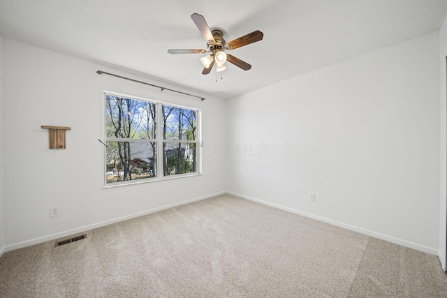 unfurnished room with baseboards, visible vents, ceiling fan, and carpet