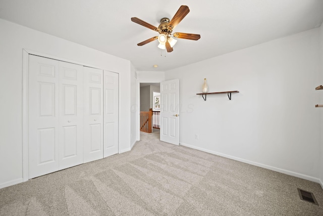 unfurnished bedroom featuring carpet, visible vents, baseboards, and a closet