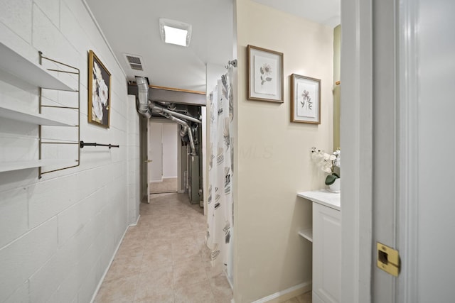 hall featuring visible vents and light tile patterned floors