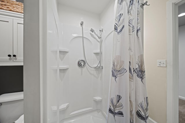 full bath featuring toilet and a shower with shower curtain