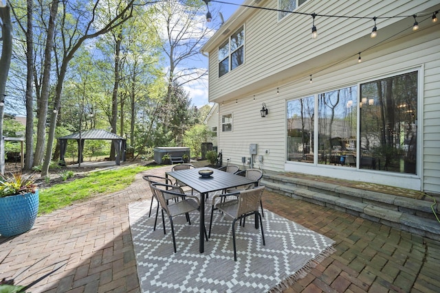 view of patio featuring a gazebo, a hot tub, and outdoor dining area
