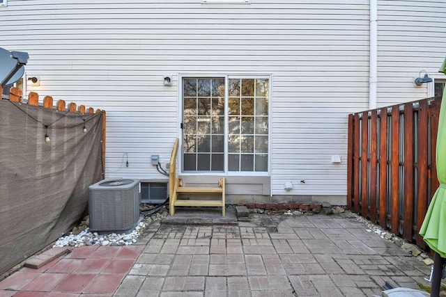 view of patio / terrace with central air condition unit, fence, and entry steps