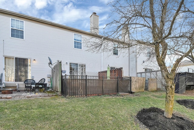 rear view of property with a patio area, a lawn, fence, and a chimney