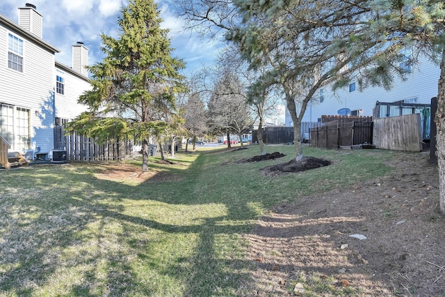 view of yard featuring cooling unit and fence