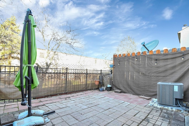 view of patio featuring central AC unit and fence