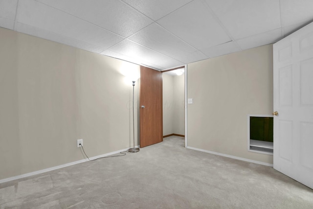 spare room featuring a paneled ceiling, baseboards, and carpet floors