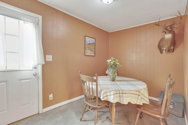 dining area featuring crown molding and baseboards