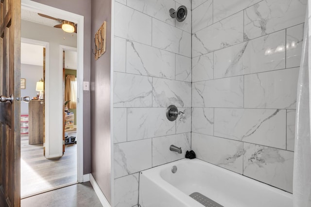 bathroom featuring shower / tub combination and baseboards