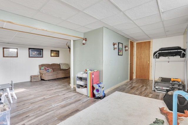 workout room featuring wood finished floors, baseboards, and a drop ceiling