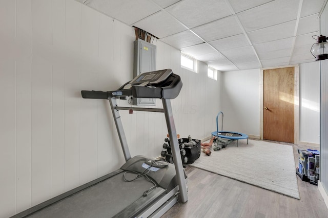 exercise area with a paneled ceiling and wood finished floors