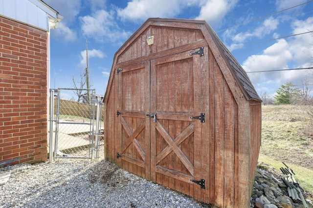 view of shed with fence and a gate