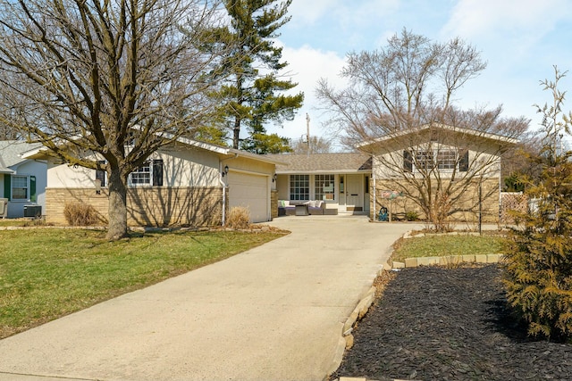 view of front facade featuring concrete driveway, brick siding, a garage, and a front lawn