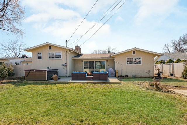 back of property featuring a hot tub, outdoor lounge area, a yard, and fence