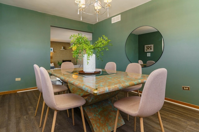 dining room with wood finished floors, visible vents, a chandelier, and baseboards