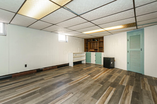 basement featuring wood finished floors and a drop ceiling