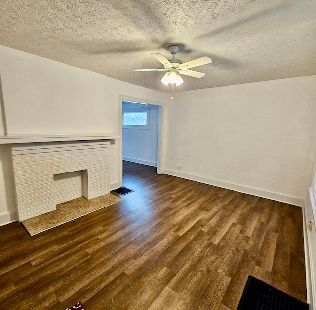 unfurnished living room featuring ceiling fan, baseboards, a brick fireplace, and dark wood-style floors