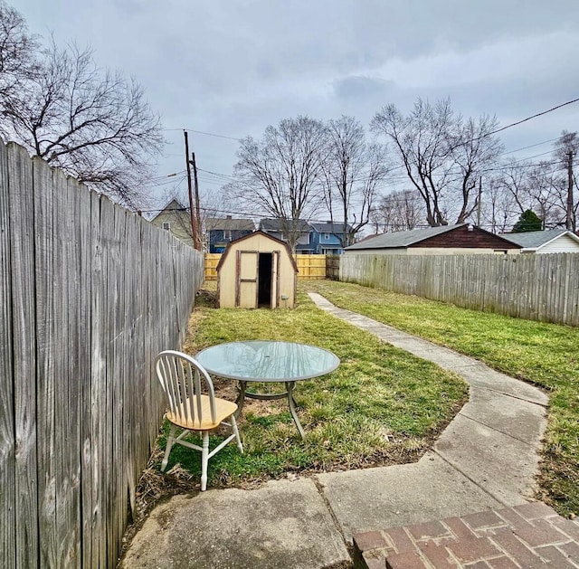 view of yard with a storage shed, an outdoor structure, and a fenced backyard