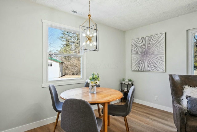 dining area with wood finished floors, visible vents, and a wealth of natural light