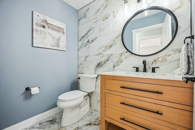 bathroom featuring vanity, baseboards, tile walls, toilet, and marble finish floor