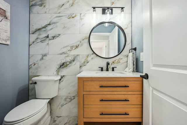 half bathroom featuring toilet, tile walls, and vanity