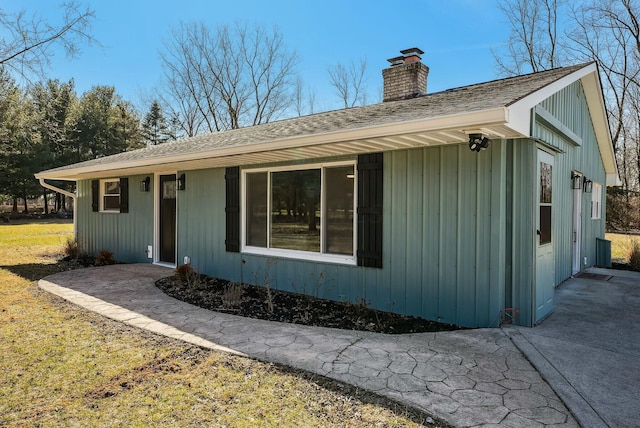 single story home featuring a shingled roof and a chimney