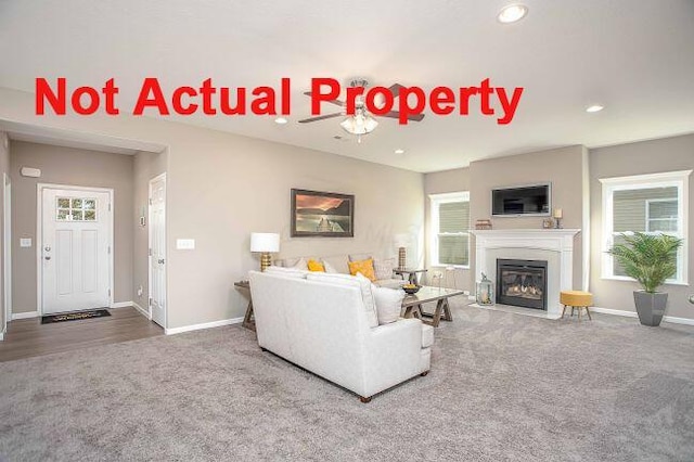 carpeted living room with recessed lighting, baseboards, and a fireplace with flush hearth