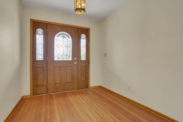 foyer entrance with baseboards and light wood-type flooring