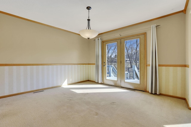 carpeted spare room featuring baseboards, visible vents, wallpapered walls, ornamental molding, and french doors