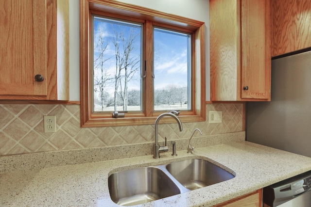 kitchen featuring a sink, tasteful backsplash, stainless steel dishwasher, and a wealth of natural light