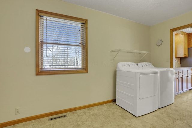 clothes washing area featuring visible vents, baseboards, independent washer and dryer, and laundry area