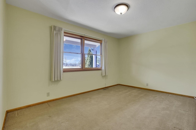 empty room with baseboards and light carpet