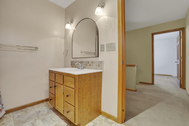 bathroom with decorative backsplash, vanity, and baseboards