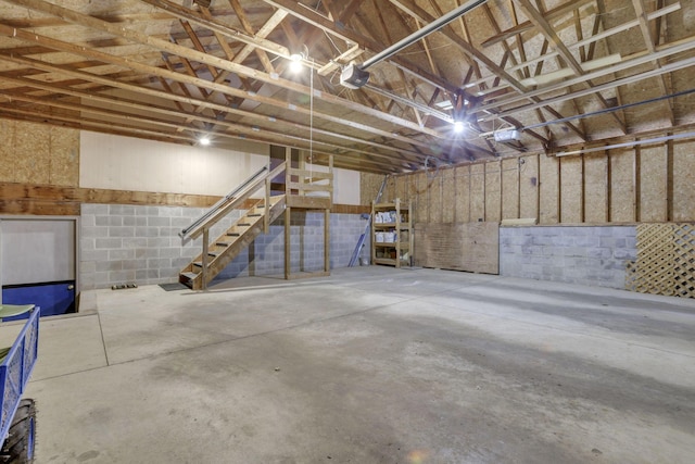 basement featuring a garage and concrete block wall