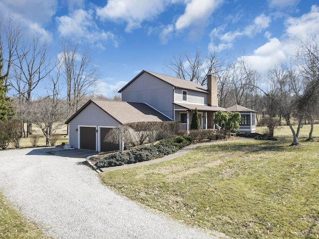 view of home's exterior featuring a chimney, a lawn, driveway, and an attached garage